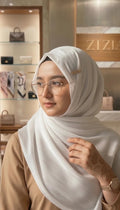 Laziaz white textured hijab scarf made of lightweight, breathable fabric with a subtle vertical stripe pattern. Secured with a gold pin.